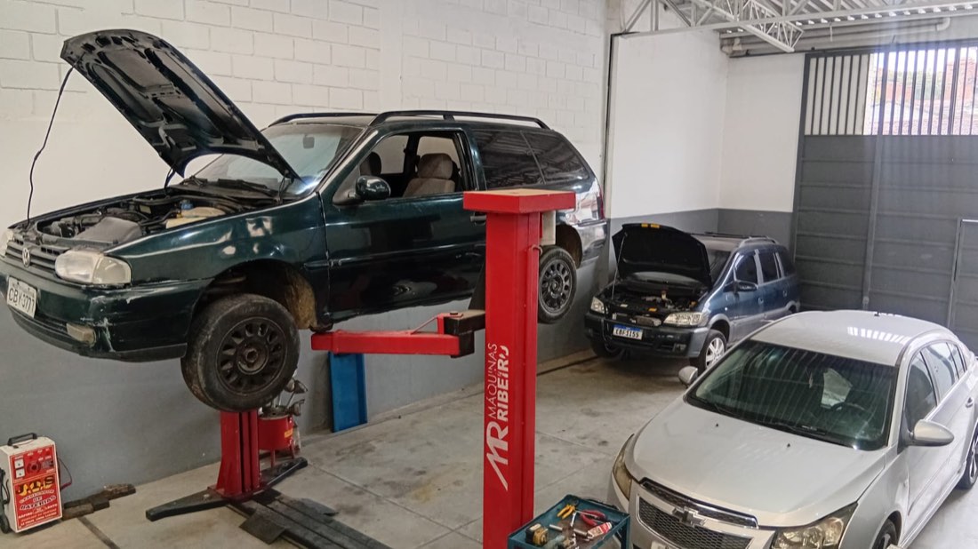 Carro sobre o elevador automotivo na oficina da RR Retífica